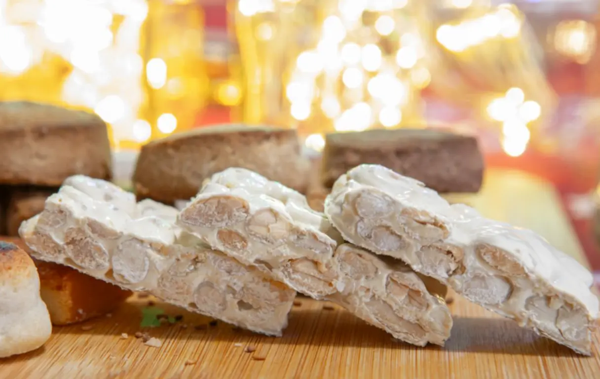 Turrón duro de Alicante en tabla de madera en tienda de dulces, Sevilla